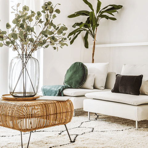 a living room with a couch and a table with a vase of flowers